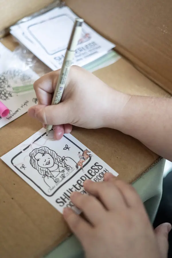 Jordan drawing a doodle portrait at the booth