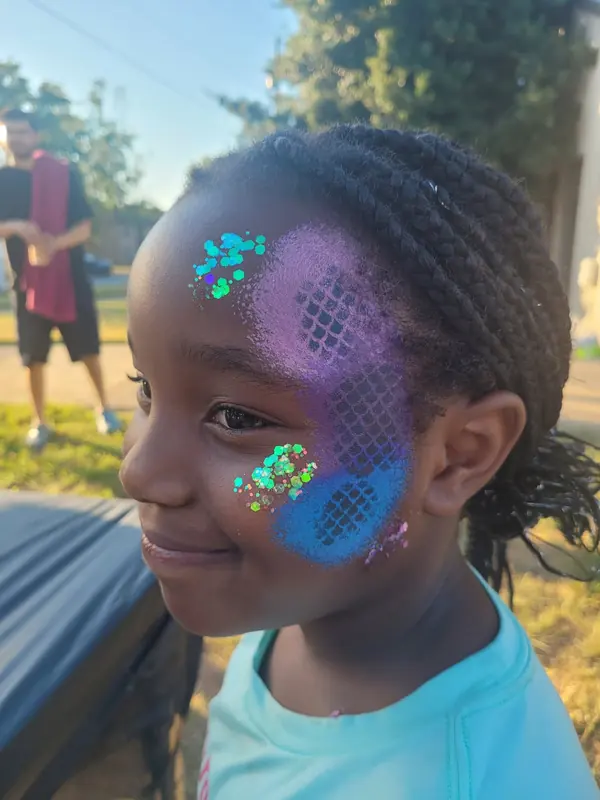 Girl with a blue mermaid-scale design and gems