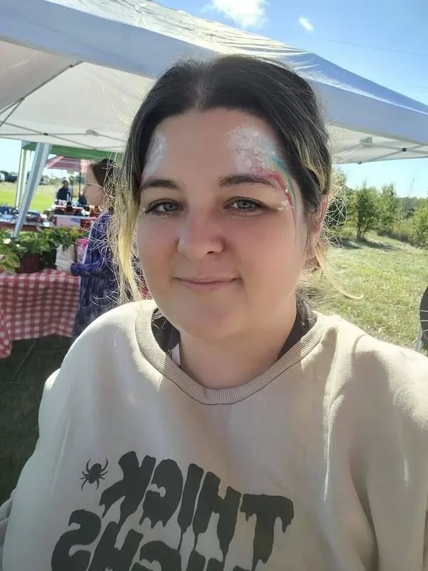 Woman with sparkly white swirls painted around her eyes