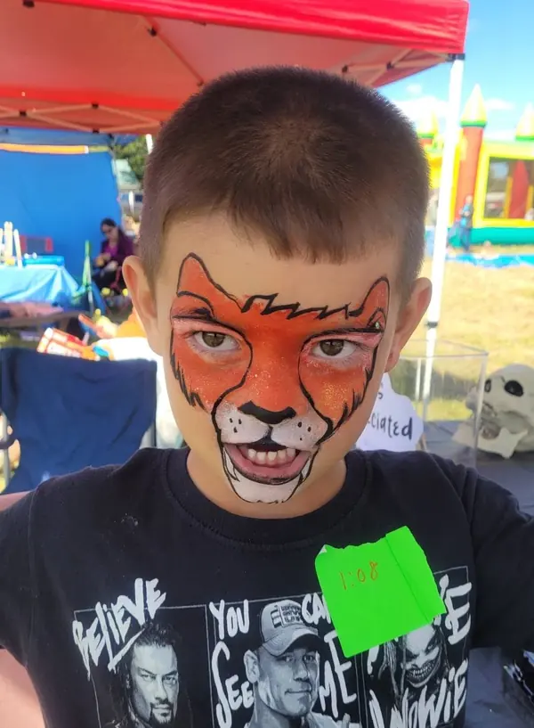 Boy with an orange tiger face paint design