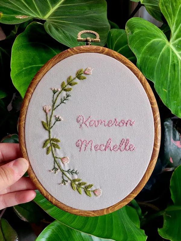 Embroidery hoop with a floral sprig and the name Kameron Michelle
