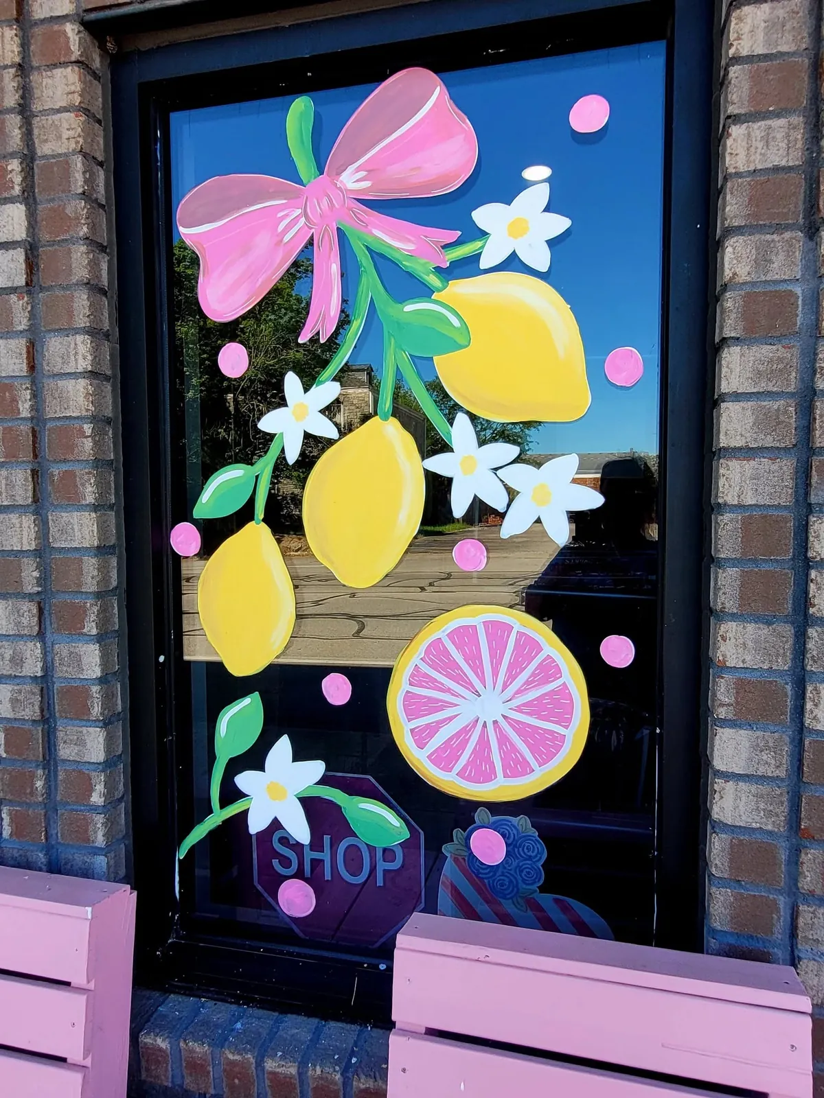 Window painted with lemons, flowers and a pink bow