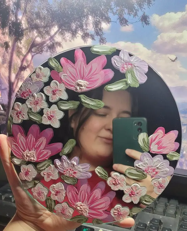 Round mirror with hand-painted pink flowers around the edge