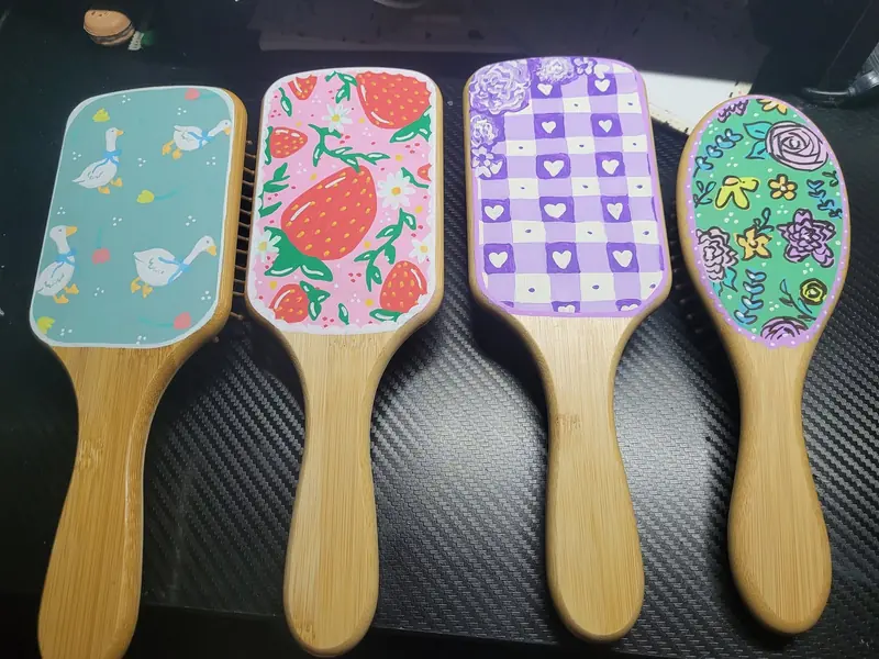 Four hand-painted hairbrushes with strawberries, gingham and flowers