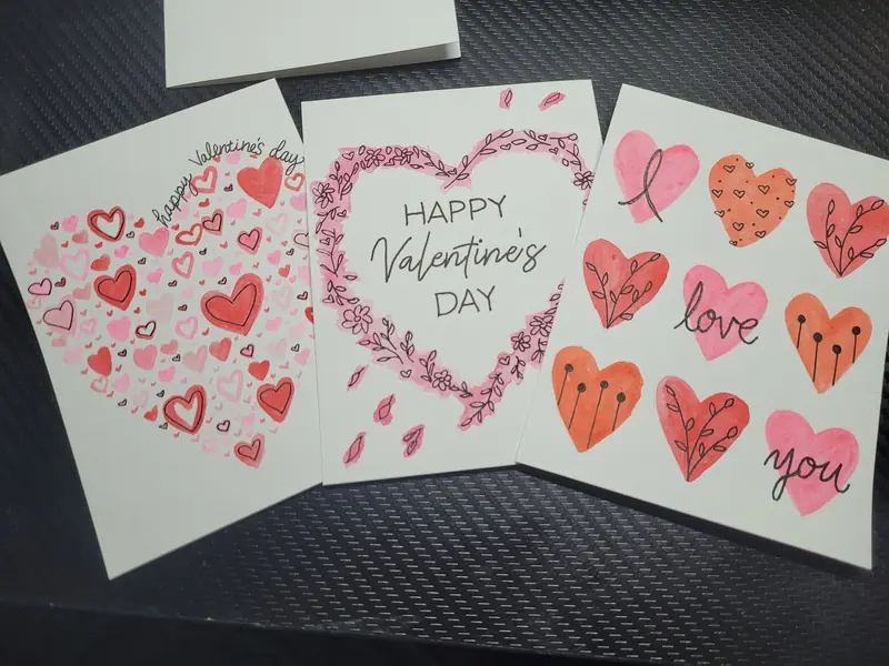 Three hand-painted Valentine's Day cards covered in hearts