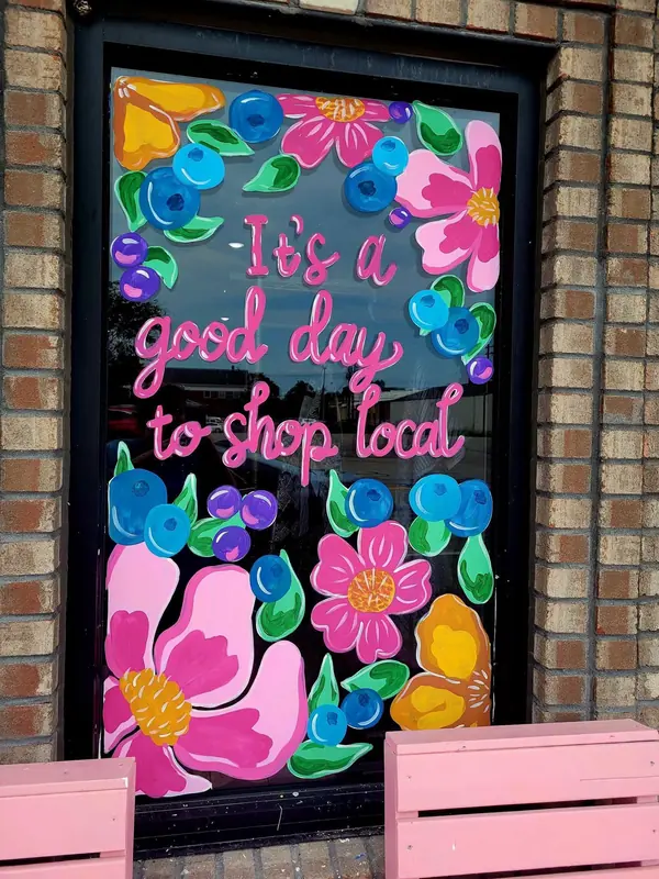 It's a Good Day to Shop Local window with oversized flowers