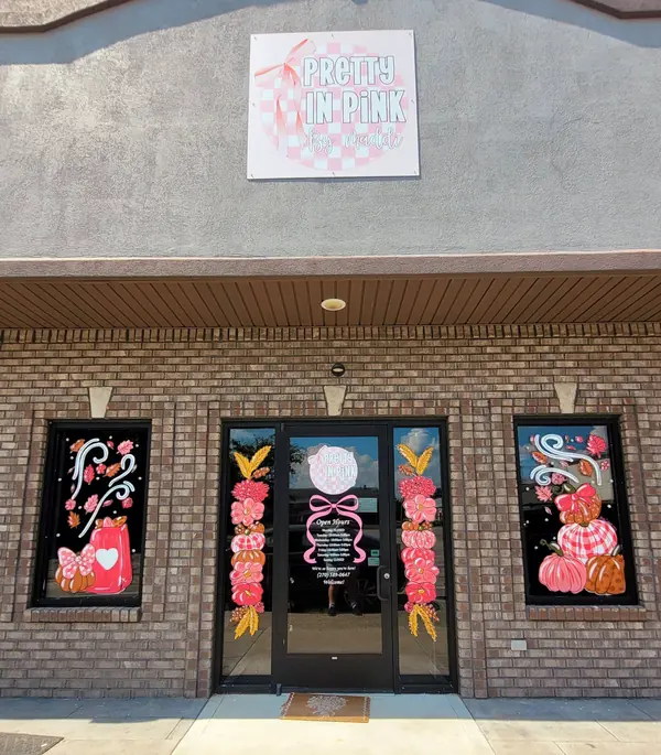 Pink fall storefront windows with bows and pumpkins